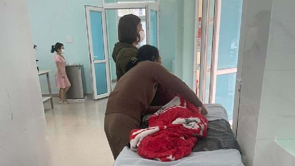 Gia đình buồn bã đứng bên thi thể cháu T.Đ.L tại Bệnh viện Sản - Nhi Quảng Ngãi.