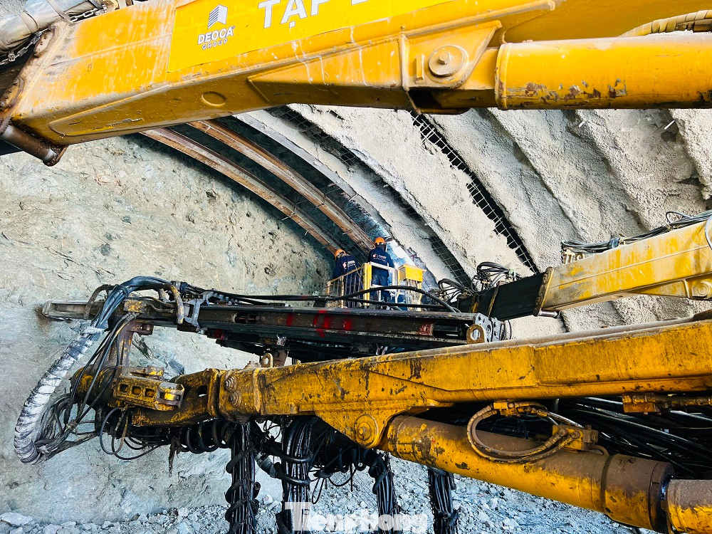 Sau khi khoan lớp mặt, nhà thầu sử dụng giá đỡ để gia cố nóc hầm và tiến hành khoan sâu vào bên trong. Sau mỗi đợt khoan sẽ phun bê tông tươi để gia cố và tăng độ bền cho công trình, ngăn không cho các khối đá biến dạng.