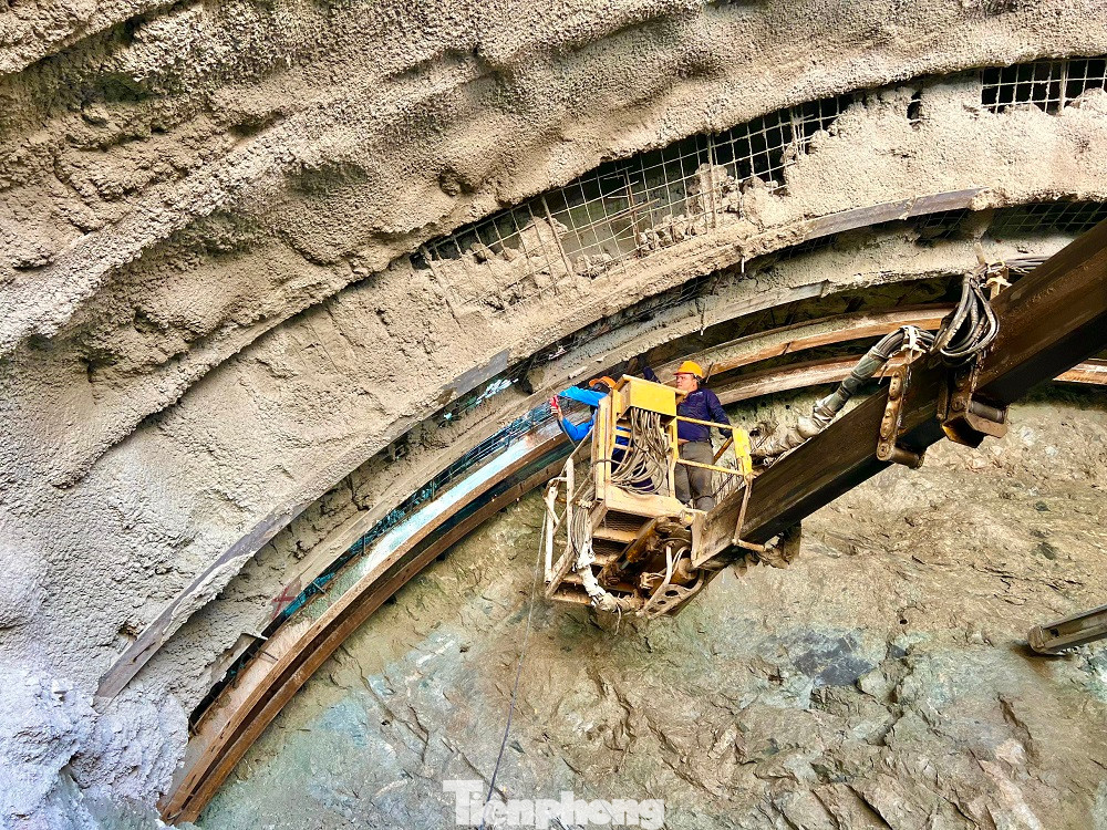 Sau khi khoan lớp mặt, nhà thầu sử dụng giá đỡ để gia cố nóc hầm và tiến hành khoan sâu vào bên trong. Sau mỗi đợt khoan sẽ phun bê tông tươi để gia cố và tăng độ bền cho công trình, ngăn không cho các khối đá biến dạng.