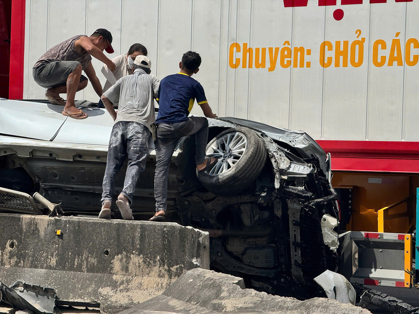 Người dân hỗ trợ các nạn nhân bên trong xe ô tô con ra ngoài. Ảnh: Nguyễn Ngọc Người dân hỗ trợ các nạn nhân bên trong xe ô tô con ra ngoài. Ảnh: Nguyễn Ngọc