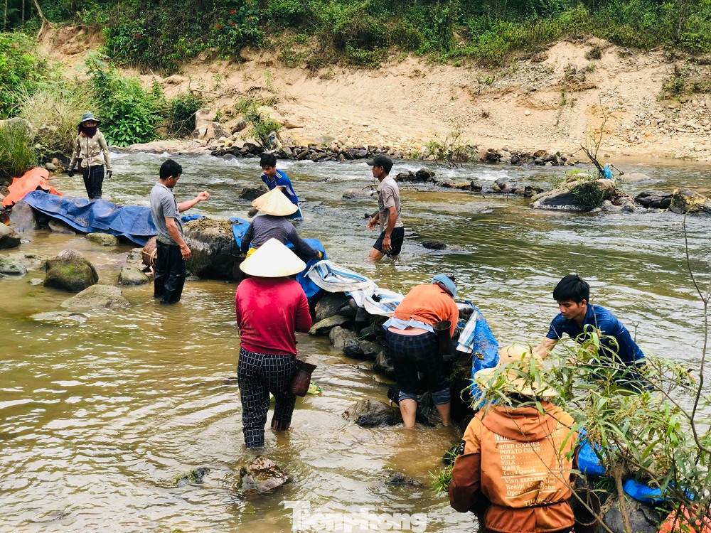 Không sử dụng lưới hay kích điện, việc bắt cá của đồng bào Hrê có nét độc đáo riêng. Đó là họ dùng đất, đá và tấm bạt để chặn một đoạn sông, ngăn đôi con nước để bắt cá. Ảnh: Nguyễn Ngọc.