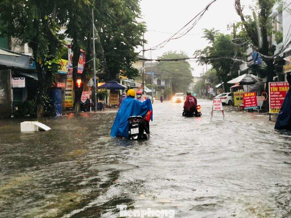 Người dân dắt xe trong &quot;biển nước&quot; trên đường Trần Hưng Đạo. Ảnh: Nguyễn Ngọc
