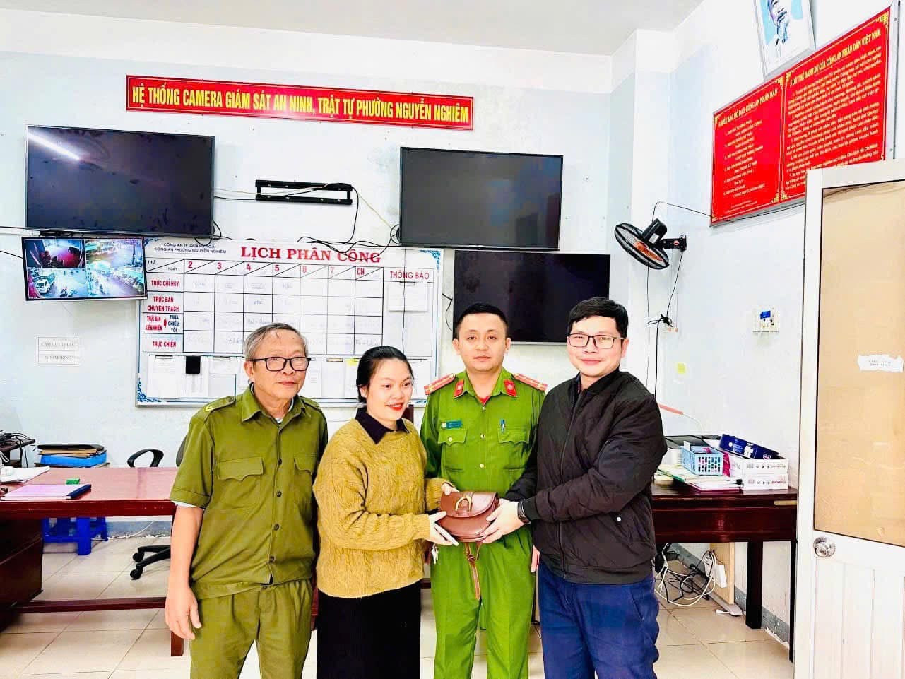 Anh Duy (phải) trả lại tài sản bị đánh rơi cho chị Trạch (trái) trước sự chứng kiến của Công an phường Nguyễn Nghiêm. Ảnh: CACC Anh Duy (phải) trả lại tài sản bị đánh rơi cho chị Trạch (trái) trước sự chứng kiến của Công an phường Nguyễn Nghiêm. Ảnh: CACC