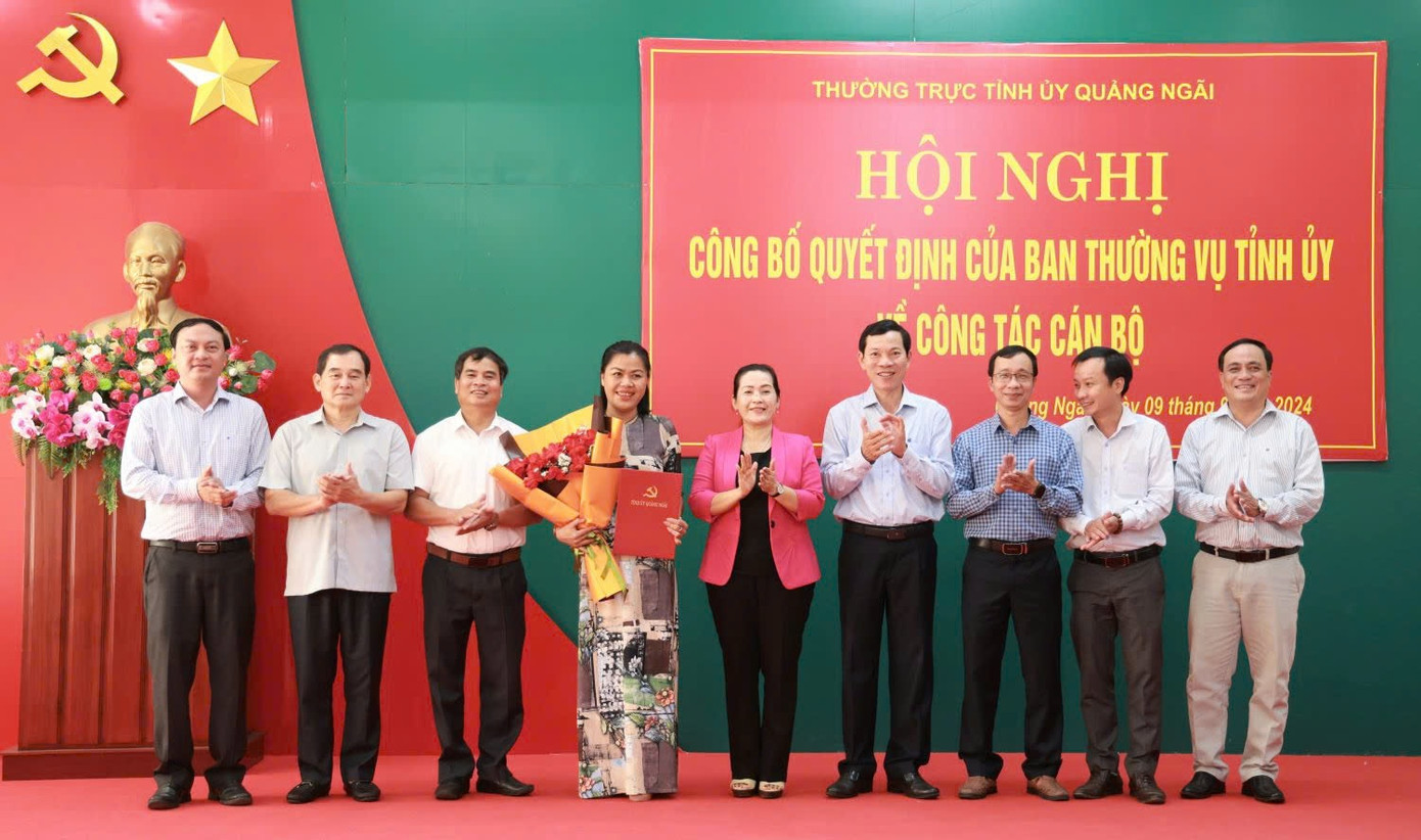 Bà Đinh Thị Hồng Minh - Phó Bí thư Tỉnh ủy Quảng Ngãi trao quyết định và tặng hoa chúc mừng bà Đinh Thị Bắc.