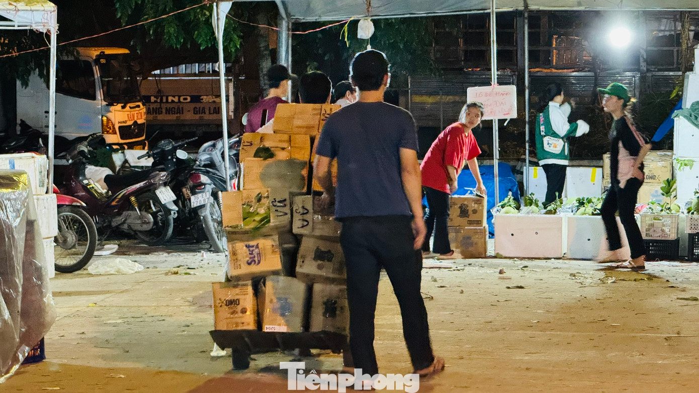 “Mỗi thùng hàng kéo từ xe vào quầy của tiểu thương được trả công 2.000 đồng. Một chuyến thường chất 10 thùng. Mỗi người thường kéo 300 - 400 thùng trong đêm, kiếm khoảng 800.000 đồng. Dịp Tết, dù công việc vất vả, kéo dài nhưng với mong muốn kiếm thêm thu nhập để trang trải cho cái Tết nên mệt mấy cũng phải làm”, anh Anh thổ lộ. Ảnh: Nguyễn Ngọc