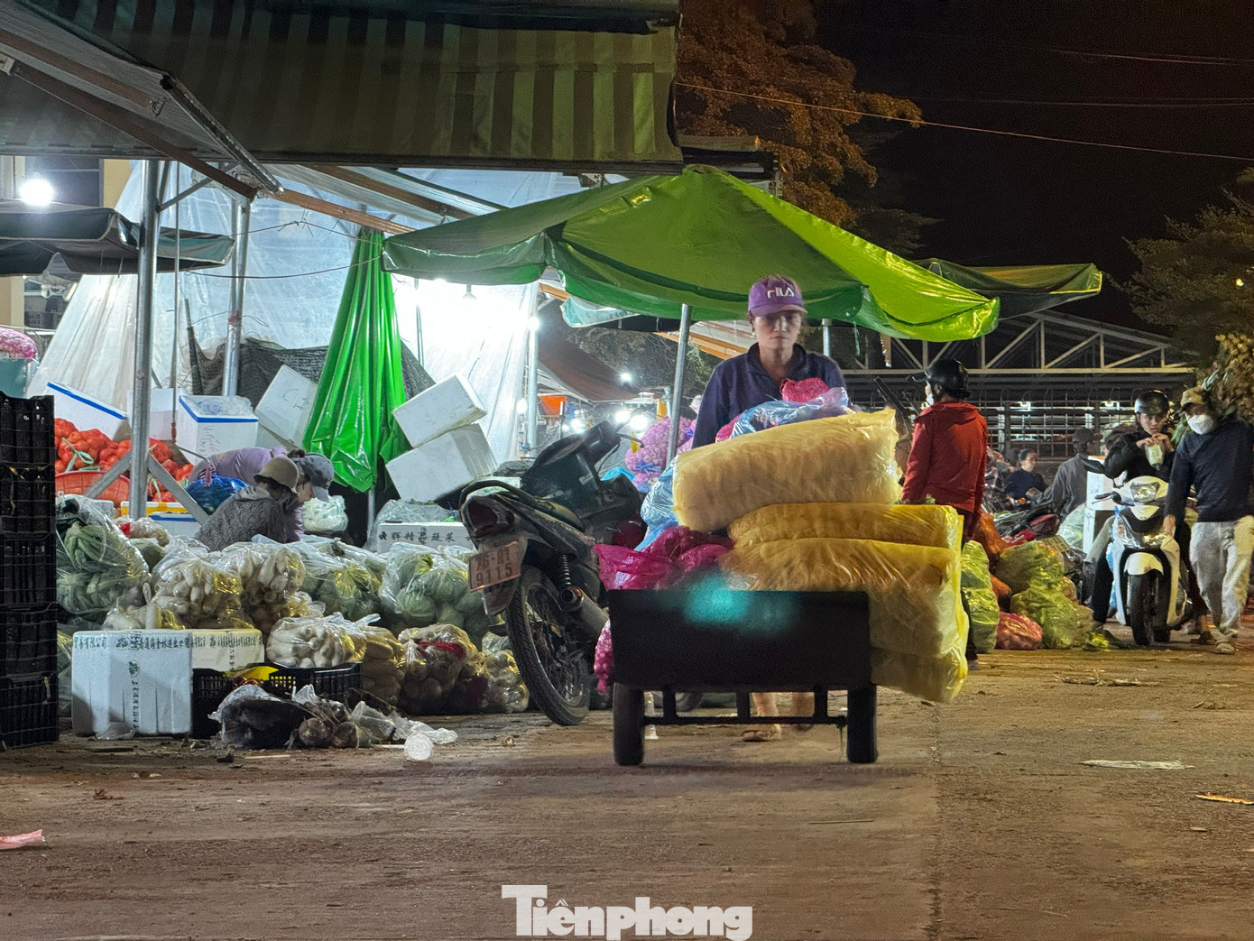 Không chỉ có “cửu vạn” là nam giới, nhiều người phụ nữ cũng làm công việc nặng nhọc này. Quan sát khắp các ngã chợ, không khó để bắt gặp hình ảnh những người phụ nữ tuổi chừng 40-50 cũng miệt mài công việc bốc hàng thuê. Họ thoăn thoắt bốc hàng vào xe rồi kéo đi. Ảnh: Nguyễn Ngọc