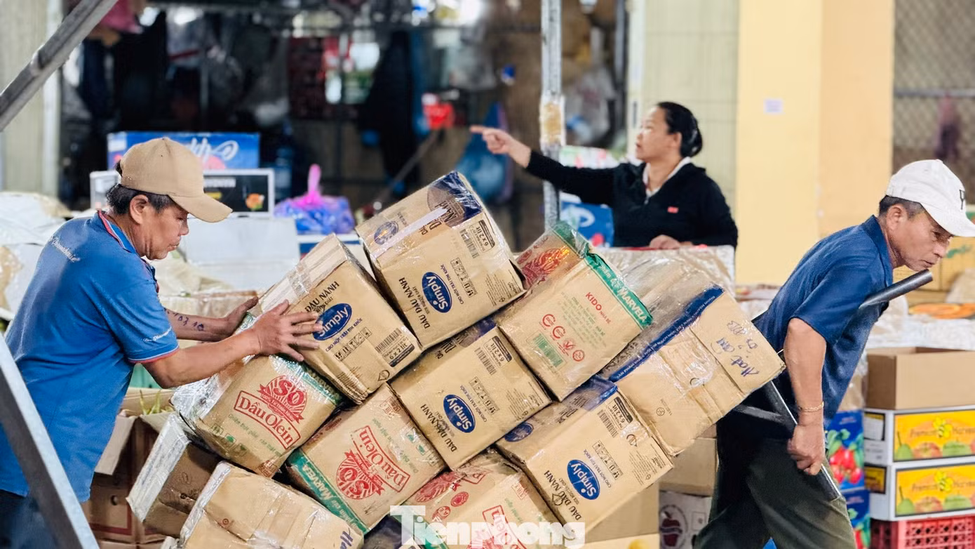 Anh Phạm Văn Anh (trú xã Nghĩa Hòa, huyện Tư Nghĩa, tỉnh Quảng Ngãi) chia sẻ, mỗi đêm kéo khoảng 300 thùng hàng đi giao khắp chợ, gần Tết tăng gấp 3-4 lần. Ảnh: Nguyễn Ngọc