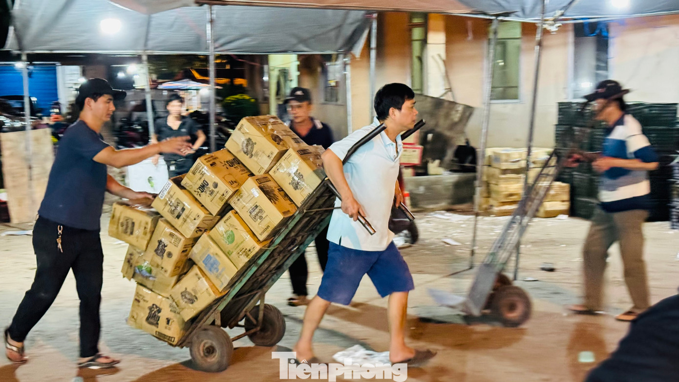 Anh Phạm Văn Anh (trú xã Nghĩa Hòa, huyện Tư Nghĩa, tỉnh Quảng Ngãi) chia sẻ, mỗi đêm kéo khoảng 300 thùng hàng đi giao khắp chợ, gần Tết tăng gấp 3-4 lần. Ảnh: Nguyễn Ngọc