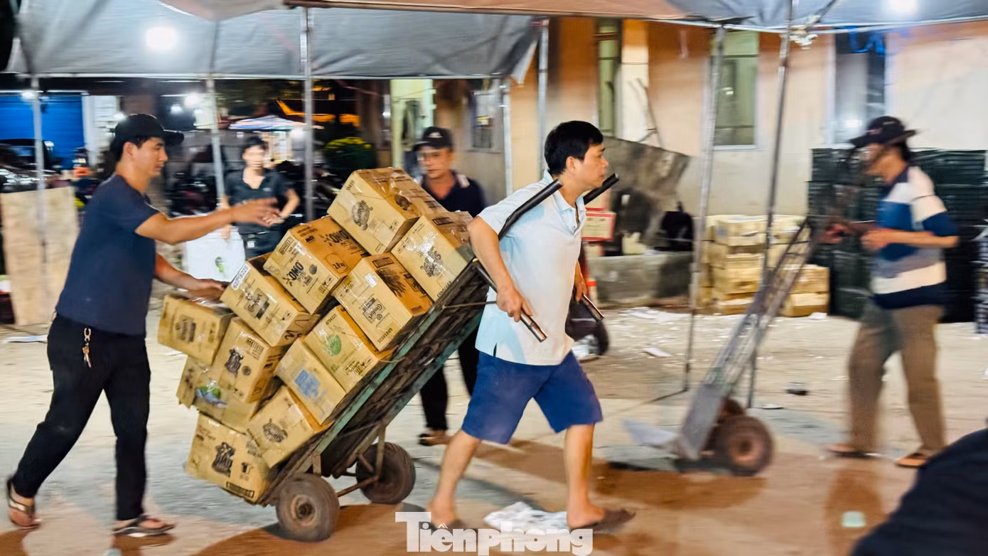 Anh Phạm Văn Anh (trú xã Nghĩa Hòa, huyện Tư Nghĩa, tỉnh Quảng Ngãi) chia sẻ, mỗi đêm kéo khoảng 300 thùng hàng đi giao khắp chợ, gần Tết tăng gấp 3-4 lần. Ảnh: Nguyễn Ngọc