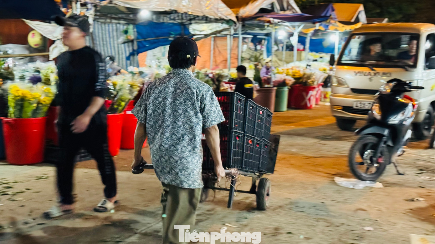 “Những ngày gần Tết, lượng hàng hóa về nhiều nên anh em làm nghề bốc vác ở chợ đầu mối phải làm việc liên tục và không màng tới giờ ngủ, khi nào hết hàng thì nghỉ. Mệt thì rất mệt nhưng bù lại có tiền để lo cho con cái có được một cái Tết ấm thì vất vả mấy cũng phải cố. Hôm nào chúng tôi cũng làm việc từ 21h cho đến 7h sáng hôm sau”, ông Phú nói. Ảnh: Nguyễn Ngọc