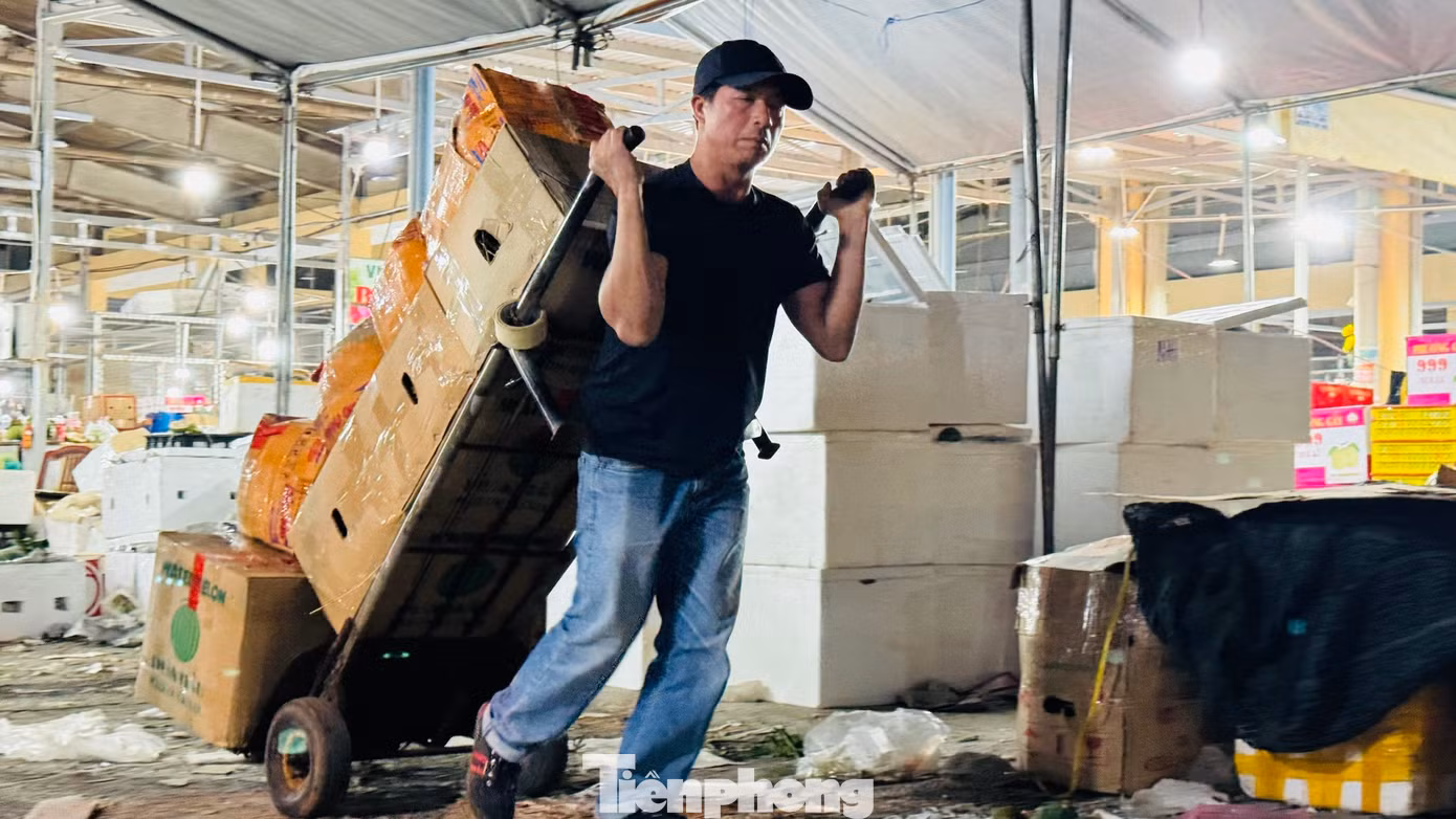 “Mỗi thùng hàng kéo từ xe vào quầy của tiểu thương được trả công 2.000 đồng. Một chuyến thường chất 10 thùng. Mỗi người thường kéo 300 - 400 thùng trong đêm, kiếm khoảng 800.000 đồng. Dịp Tết, dù công việc vất vả, kéo dài nhưng với mong muốn kiếm thêm thu nhập để trang trải cho cái Tết nên mệt mấy cũng phải làm”, anh Anh thổ lộ. Ảnh: Nguyễn Ngọc