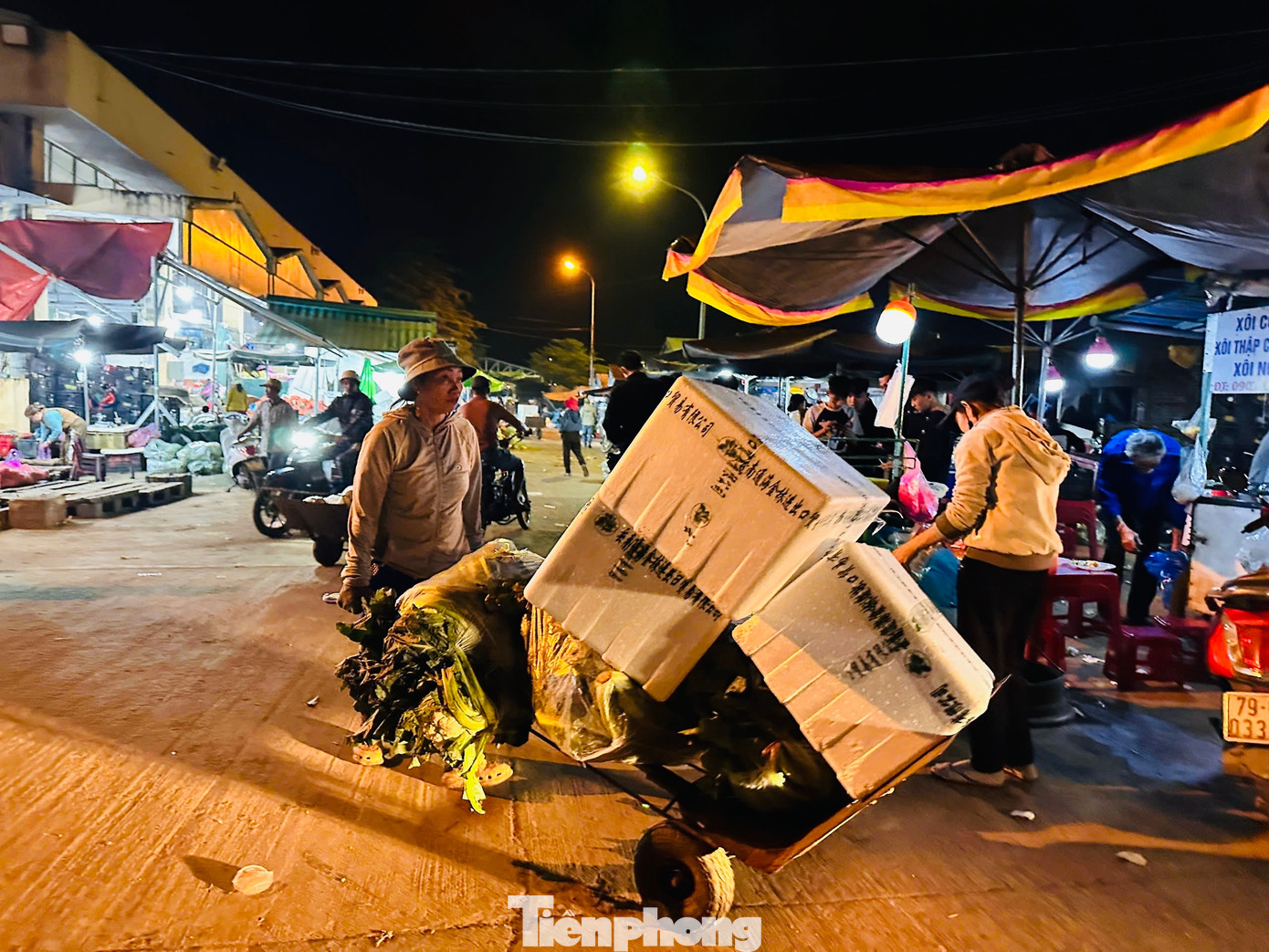 Không chỉ có “cửu vạn” là nam giới, nhiều người phụ nữ cũng làm công việc nặng nhọc này. Quan sát khắp các ngã chợ, không khó để bắt gặp hình ảnh những người phụ nữ tuổi chừng 40-50 cũng miệt mài công việc bốc hàng thuê. Họ thoăn thoắt bốc hàng vào xe rồi kéo đi. Ảnh: Nguyễn Ngọc