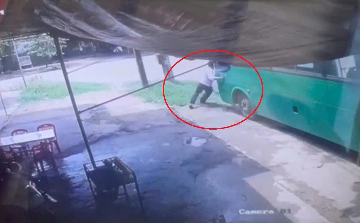 Người phụ xe cố ngăn xe buýt di chuyển. Ảnh: Cắt từ clip