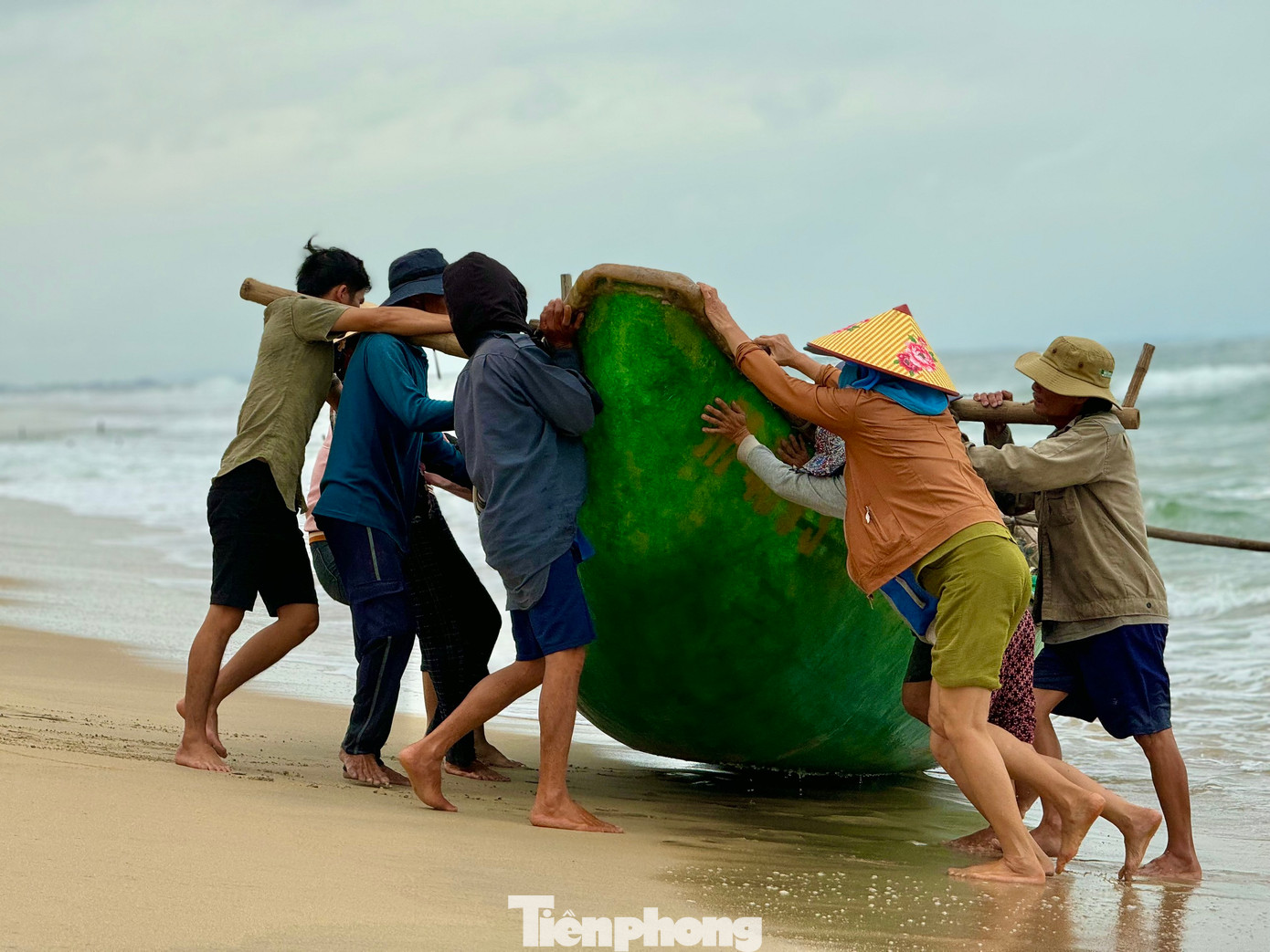 Ngay khi thuyền vừa cập bờ, những người vợ của ngư dân cũng khẩn trương ra hỗ trợ chồng con đưa chiếc thuyền vào sâu trong bờ để tránh những con sóng lớn.