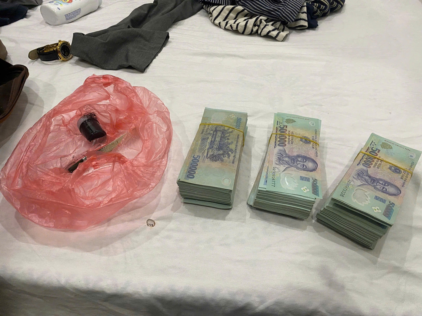 Tang vật xấp tiền USD giả và 500 triệu đồng của người bị hại.