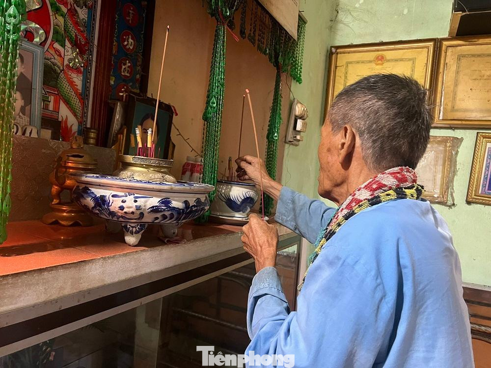 Ông Sáu thắp nén nhang cho con trước khi đi sơ tán tránh bão Noru