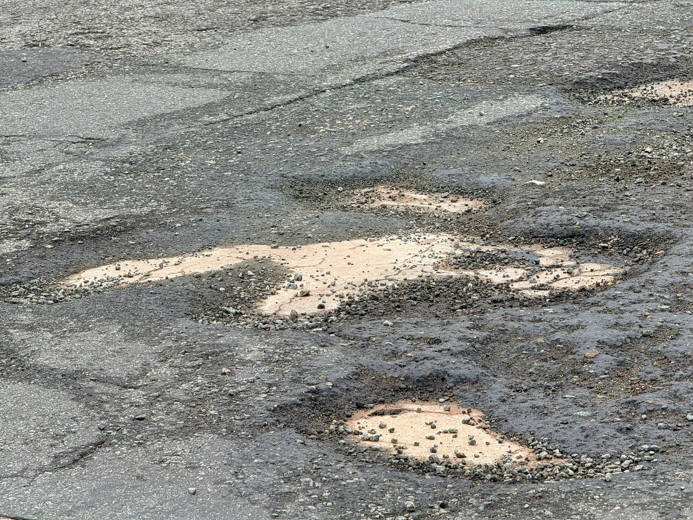 Mặt đường bị bong tróc, lồi lõm.