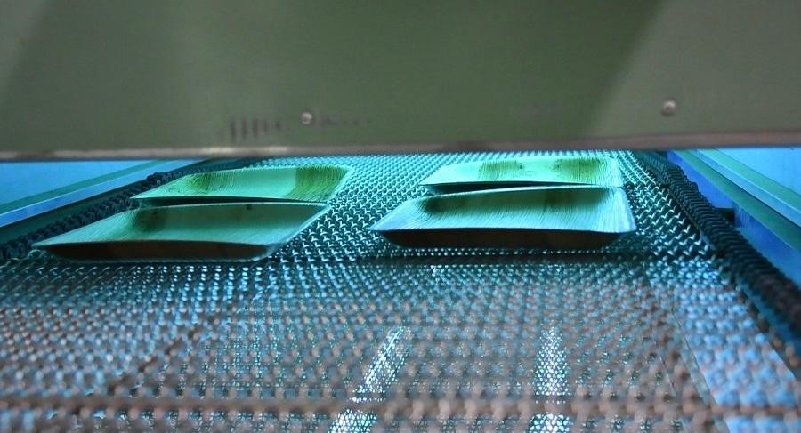 Sau khi qua máy ép nhiệt, các sản phẩm được chiếu tia UV khử trùng. Ảnh: Nguyễn Ngọc Sau khi qua máy ép nhiệt, các sản phẩm được chiếu tia UV khử trùng. Ảnh: Nguyễn Ngọc