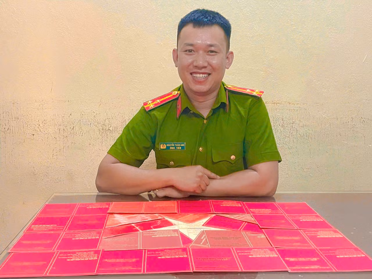 Lá cờ được xếp từ hàng chục giấy chứng nhận hiến máu tình nguyện của Thượng úy Nguyễn Tuấn Anh. Ảnh: NVCC