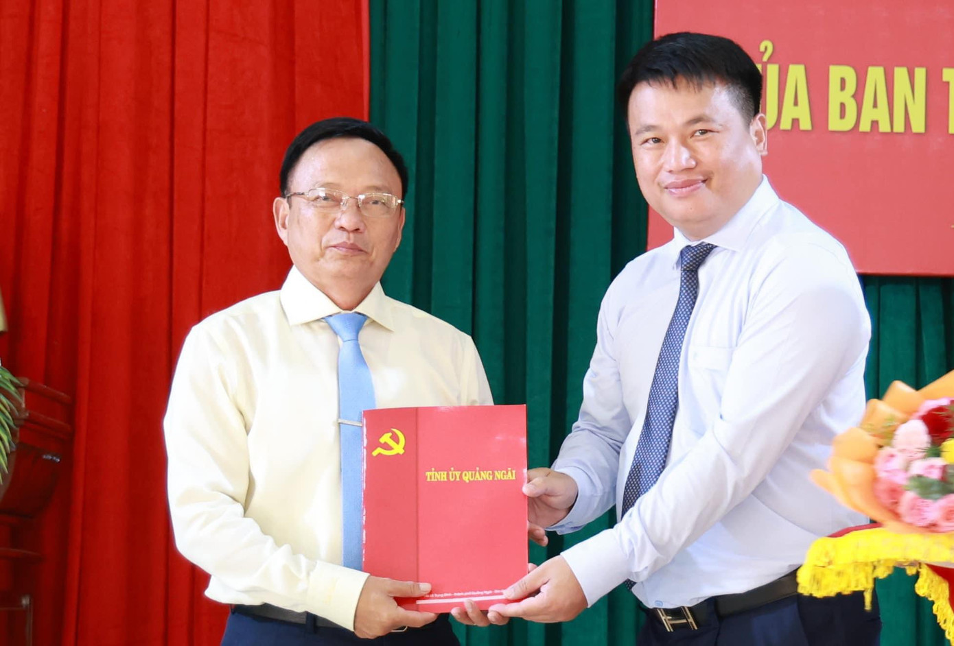 Ông Đặng Ngọc Huy - Phó Bí thư thường trực Tỉnh ủy, Trưởng đoàn ĐBQH tỉnh Quảng Ngãi (bên phải) trao quyết định và tặng hoa chúc mừng ông Phạm Xuân Vinh.