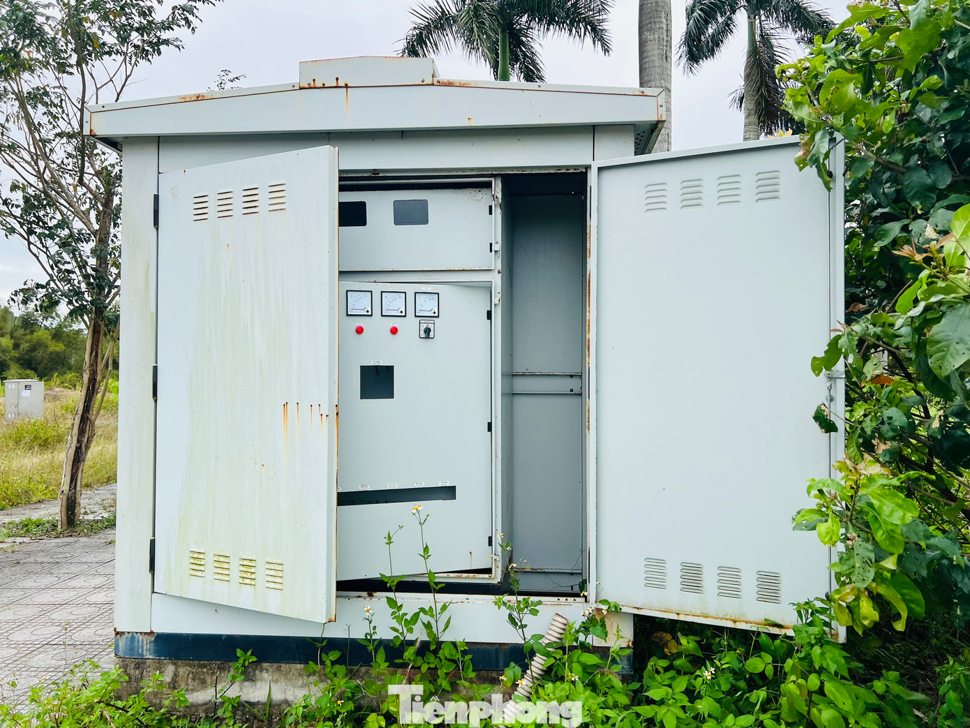 Một số tủ điện đã bung nắp, cỏ dại phủ lên trên. Nhiều cống thoát nước thi công dang dở, hệ thống hố ga thu nước mưa không có nắp đậy tạo thành những cái bẫy. Ảnh: Nguyễn Ngọc