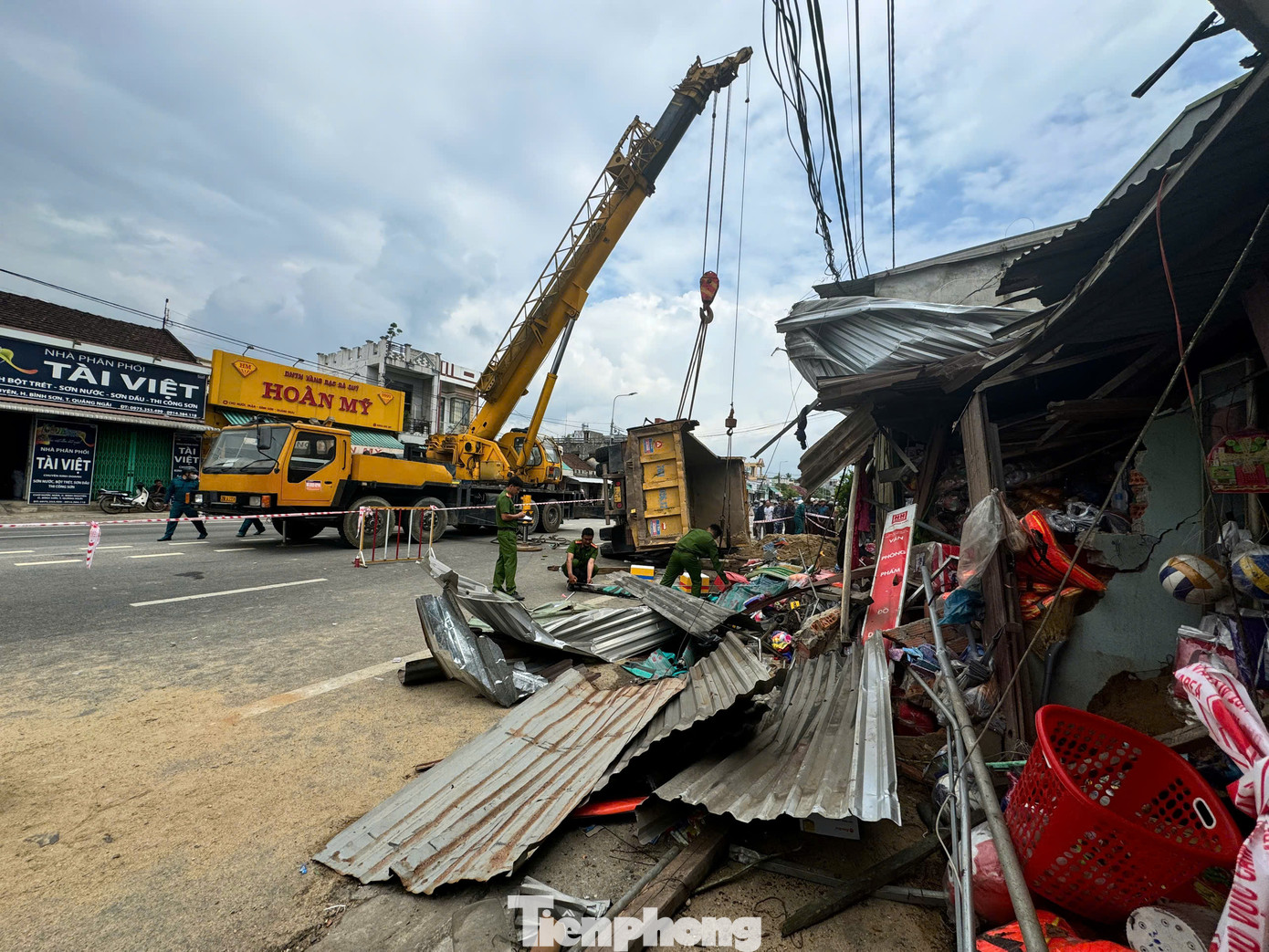 Tại hiện trường, xe tải chở cát ủi bay hàng loạt mái hiên nhà dân.