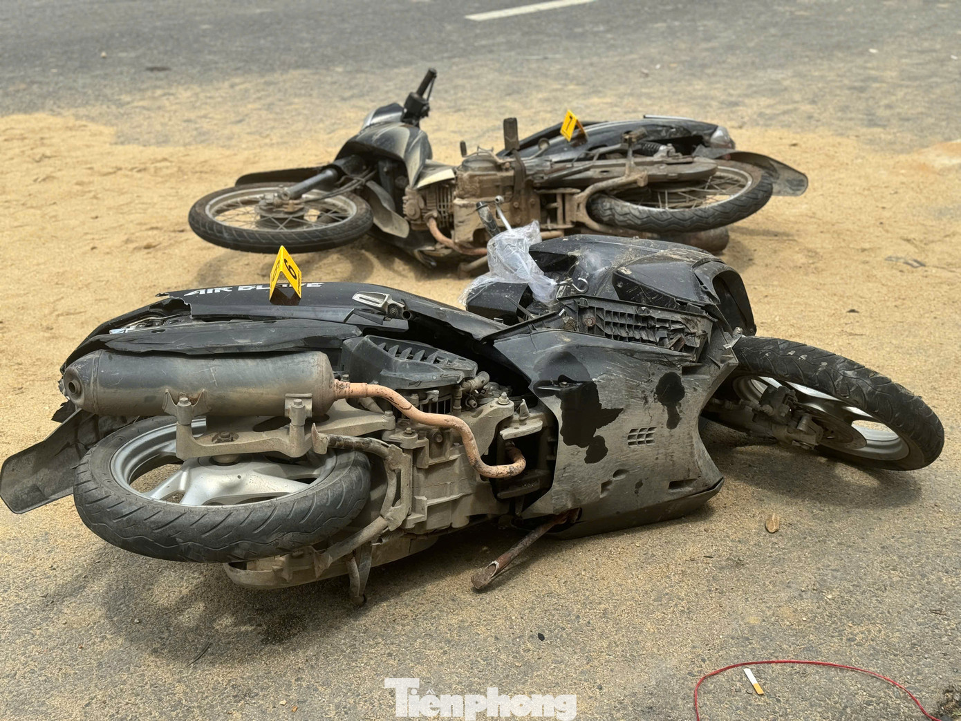 Tại hiện trường, nhiều xe máy nằm la liệt trên đường, xe tải chở đất tông vào hàng loạt mái hiên nhà dân rồi lật ngang, cát trên xe văng tung tóe. Ảnh: Nguyễn Ngọc