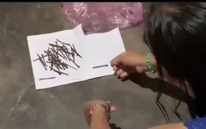 Số đinh được đăng tải trong clip cho rằng đã lấy từ trong người phụ nữ. (Ảnh cắt từ video)