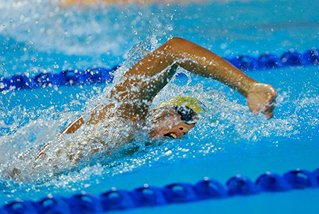 Nước bắn tung trong khi một VĐV thực hiện bài thi trên đường đua xanh. Nước bắn tung trong khi một VĐV thực hiện bài thi trên đường đua xanh