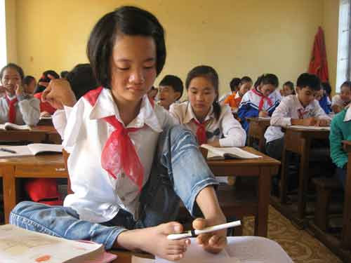 Em khéo léo dùng hai bàn chân nắp bút lại sau tiết học