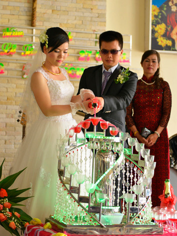 Cô dâu Bích Trầm cầm tay chú rể Xuân Long trong nghi thức rót rượu hồng. Cô dâu Bích Trầm cầm tay chú rể Xuân Long trong nghi thức rót rượu hồng