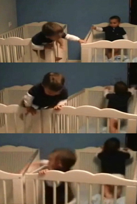 Không thích cảnh mỗi người một cũi, một bé trai trèo lên thành cũi và kéo lại gần để nhảy sang cũi còn lại