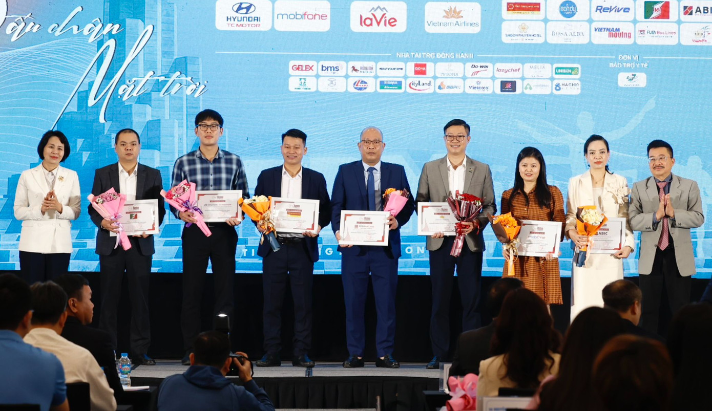 Bà Lê Thị Hoàng Yến - Phó Cục trưởng Cục Thể dục thể thao (bìa trái) và nhà báo Vũ Tiến – Phó Tổng biên tập báo Tiền Phong, Phó trưởng Ban tổ chức Tiền Phong Marathon 2024 (bìa phải), trao hoa và chứng nhận tài trợ tặng các nhà tài trợ Bạc, nhà tài trợ Đồng và nhà tài trợ vận chuyển.