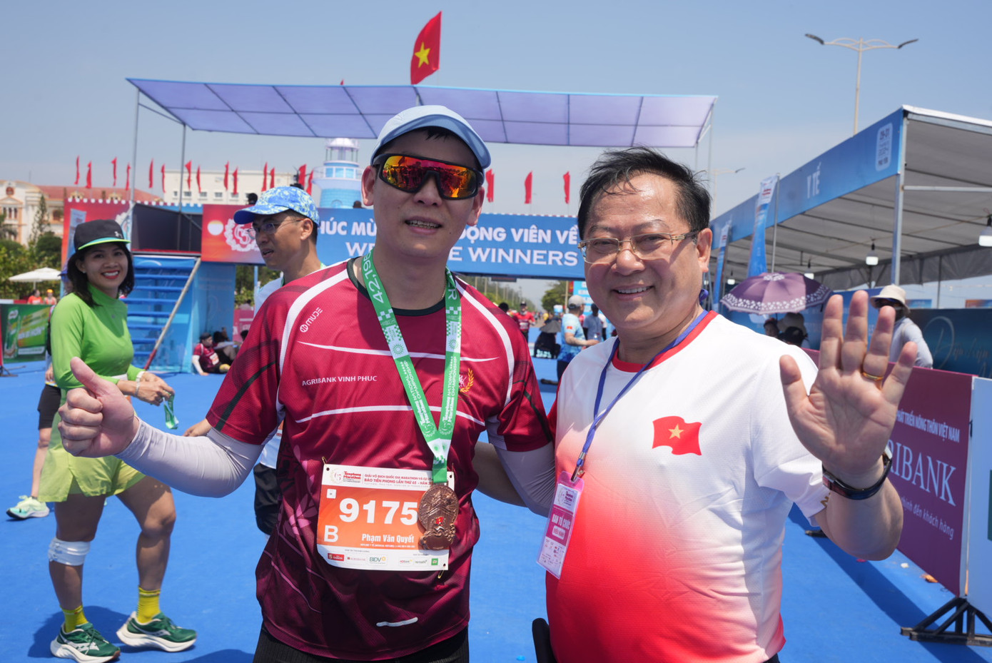 Nhà báo Lê Xuân Sơn - Tổng Biên tập báo Tiền Phong, đồng Trưởng Ban tổ chức Tiền Phong Marathon 2024, trao huy chương tặng vận động viên ở vạch đích.