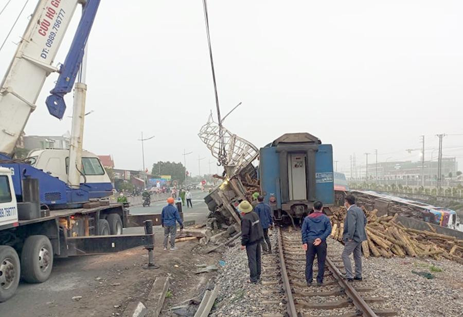 L Lực lượng cứu hộ đang nỗ lực khắc phục sự cố để sớm thông lại đường sắt. Ảnh: Đức Thắng.