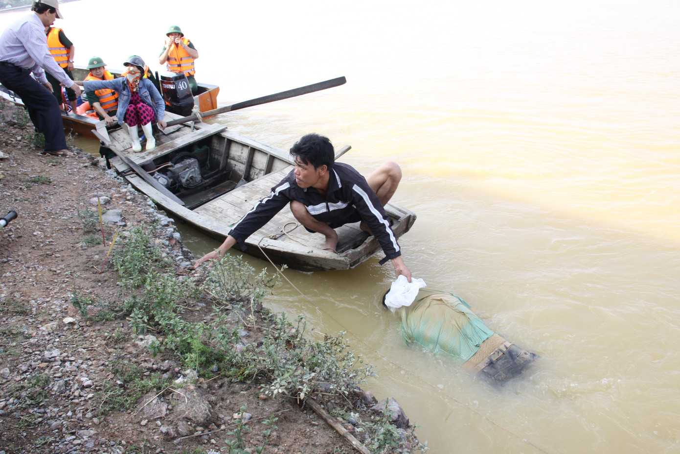 Đưa xác nạn nhân lên bờ. Ảnh: Phan Sáng - Quang Dũng. Đưa xác nạn nhân lên bờ. Ảnh: Tiền Phong