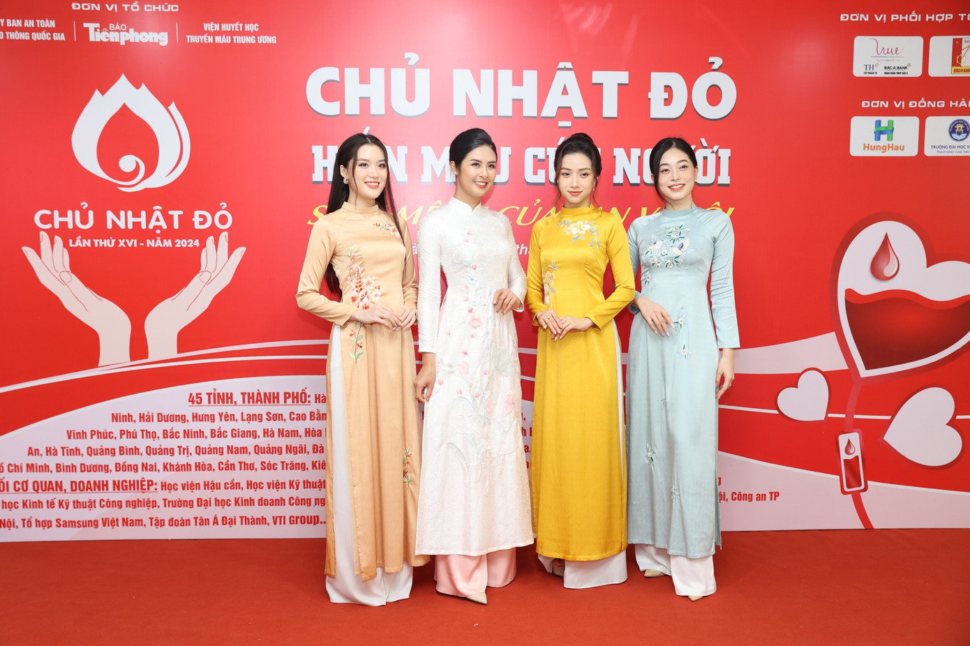 Dàn người đẹp diện áo dài nền nã, chụp ảnh cùng ban tổ chức, khách mời trên thảm đỏ.