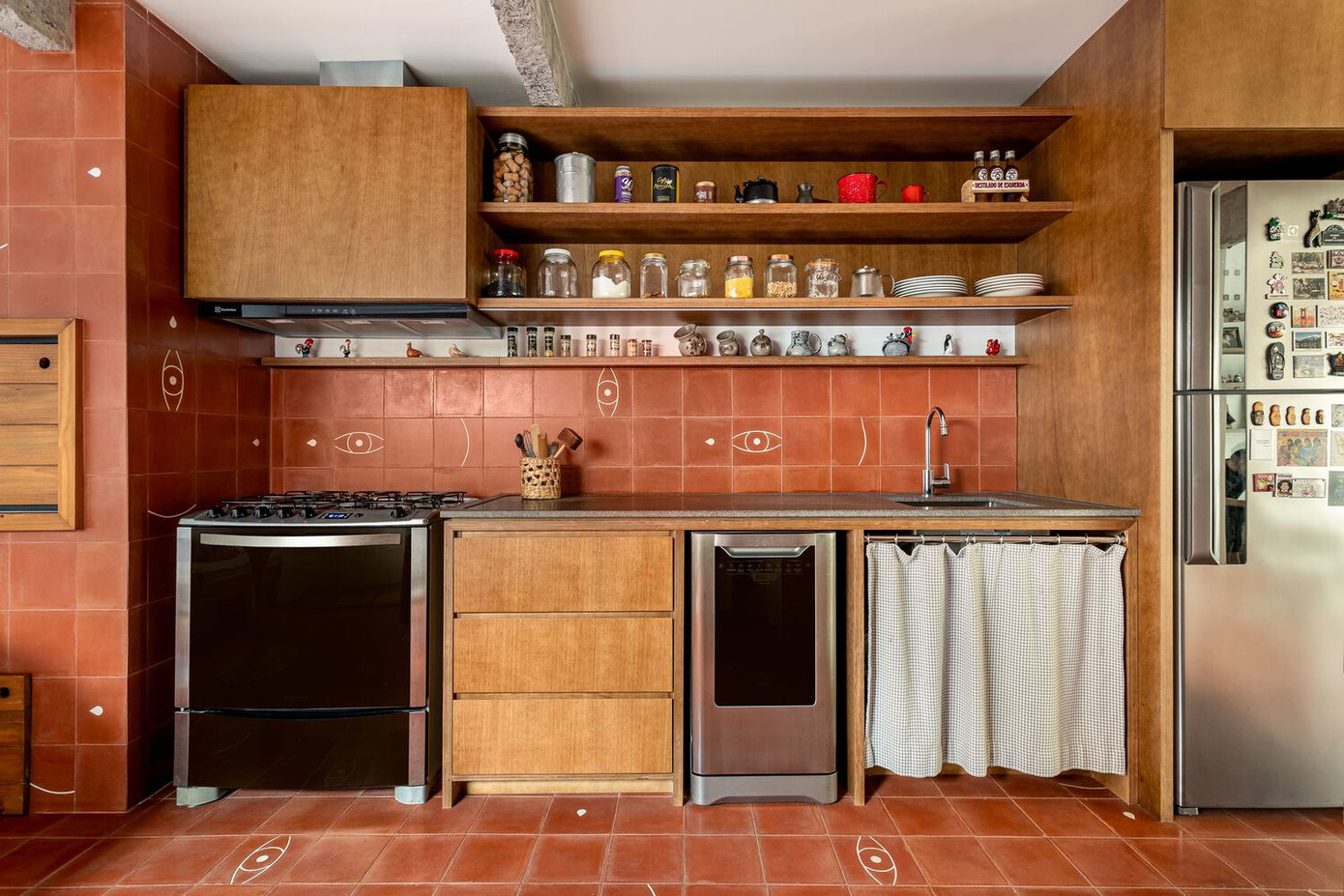 Tại khu vực bếp, gạch bông thủ công màu đất nung được lựa chọn cho cả sàn lẫn tường, tạo nên một tổng thể thống nhất cho gian bếp. Những viên gạch với màu sắc đậm và hoạ tiết tinh xảo tạo điểm nhấn văn hoá và cá tính rực rỡ cho không gian. Nhiều món nội thất cũ được giữ lại có chọn lọc và bố trí khéo léo trong bố cục mới.