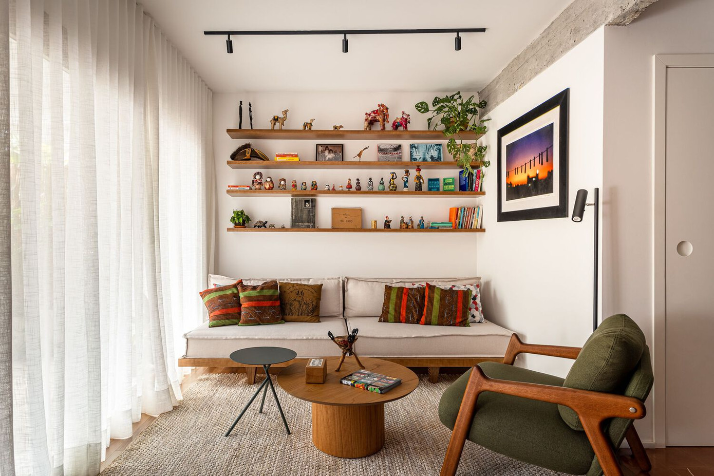 Dọc theo một bên tường trong phòng khách là hệ tủ liên hoàn, chi tiết về cả công năng lẫn thẩm mỹ. Đây vừa là kệ tivi, ghế ngồi tích hợp, vừa kéo dài thành bàn bếp, tủ chứa đồ liền mạch từ phòng khách sang bếp. Đặc biệt, một lò sưởi nhỏ được đặt tích hợp khéo léo trở thành điểm nhấn ấm cũng giữa không gian hiện đại.