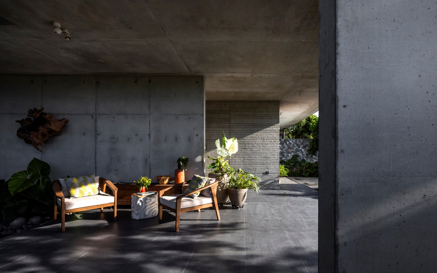 Bê tông thô mộc được giữ lại mọi dấu vết thi công, trở thành câu chuyện của chính công trình. Khi nắng chiếu lên, những mảng tường xám bỗng trở nên mềm mại, ấm áp.