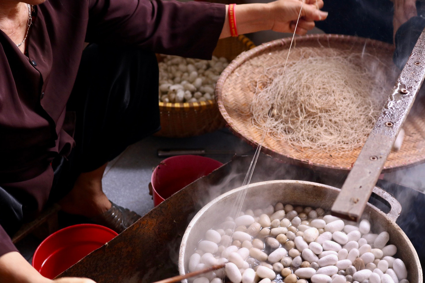 Bên cạnh nồi nước sôi sùng sục luôn có người túc trực để nấu kén, kéo sợi. Kén sẽ được vào một nồi nước sôi lớn, khuấy đều cho các kén nổi lên trên. Khi lớp áo đã bong ra, người trông bếp sẽ tìm mối gốc của tơ và rút ra rồi đưa lên guồng tơ nằm ngang trên nồi để quấn lại. Sợi tơ vừa mới rút ra được gọi là tơ thô, và sau đó chúng sẽ được se lại với nhau. Bên cạnh nồi nước sôi sùng sục luôn có người túc trực để nấu kén, kéo sợi. Kén sẽ được vào một nồi nước sôi lớn, khuấy đều cho các kén nổi lên trên. Khi lớp áo đã bong ra, người trông bếp sẽ tìm mối gốc của tơ và rút ra rồi đưa lên guồng tơ nằm ngang trên nồi để quấn lại. Sợi tơ vừa mới rút ra được gọi là tơ thô, và sau đó chúng sẽ được se lại với nhau.