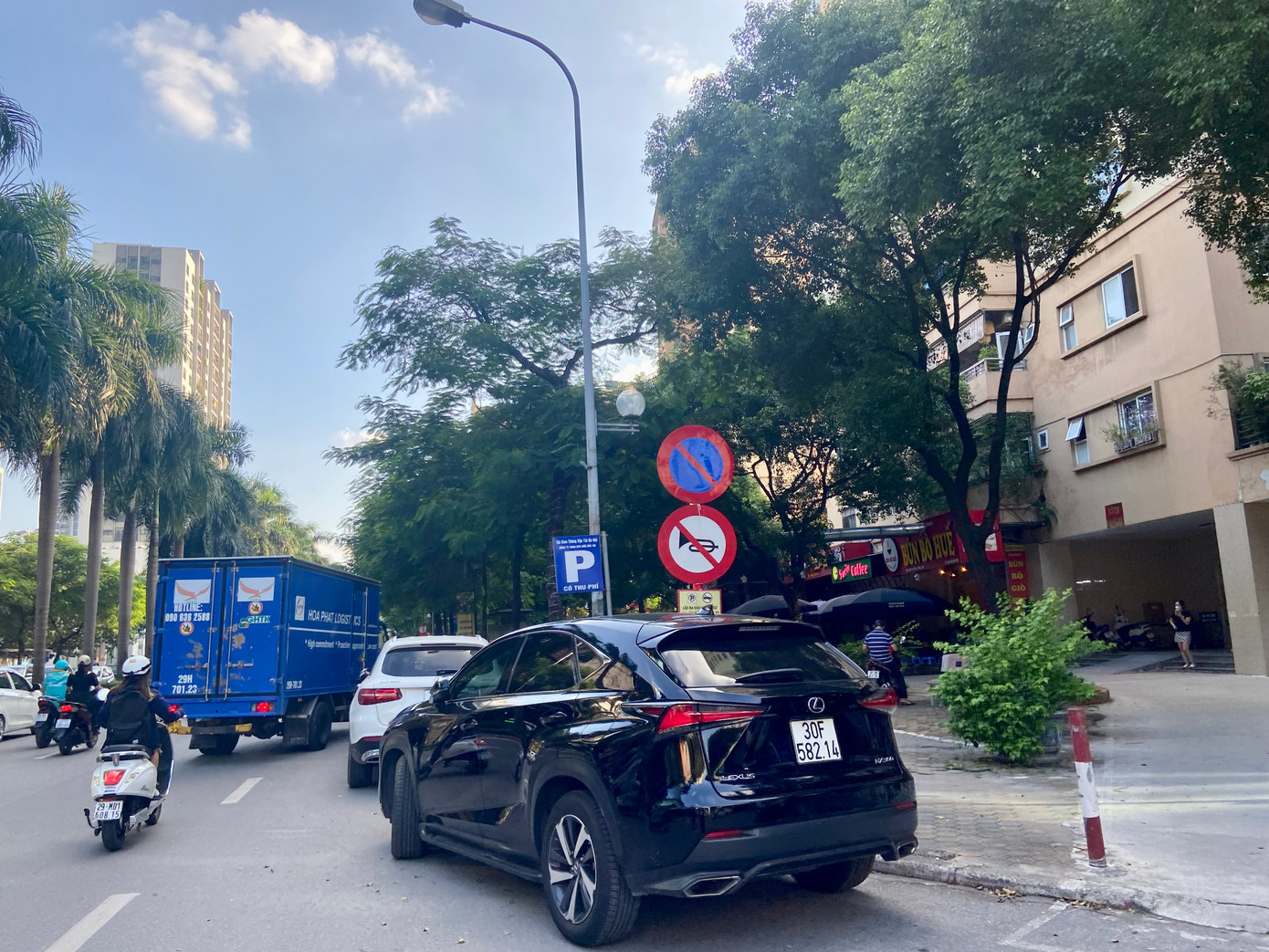 Ô tô đỗ ngay dưới biển cấm đỗ xe, tại một ngã rẽ trên đường Lê Đức Thọ