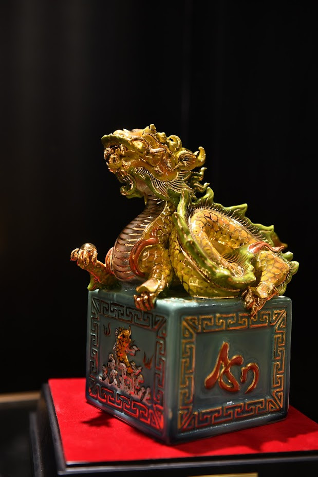 Trên 3 mặt của sản phẩm được tạo hình 3 chữ nổi An - Thuận - Phát, mặt còn lại được khắc cảnh cá chép hóa rồng nhằm thể hiện sự lột xác, là dấu ấn cho một khởi đầu mới.