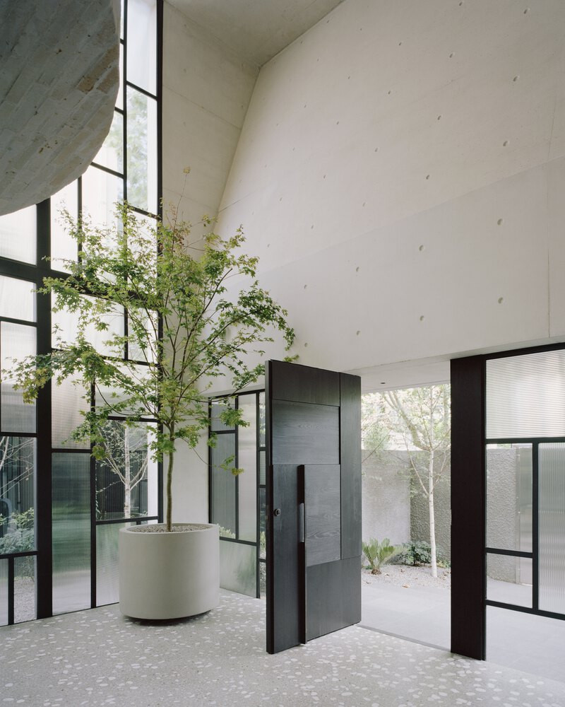 Trần nhà được bo cong nhẹ nhàng, tạo cảm giác uyển chuyển giữa các khối vật liệu tưởng chừng đối nghịch. Chính sự mẫu thuẫn đầy dụng ý này đã tạo nên bản giao hưởng ánh sáng - bóng tối, mềm - cứng trong từng góc không gian.