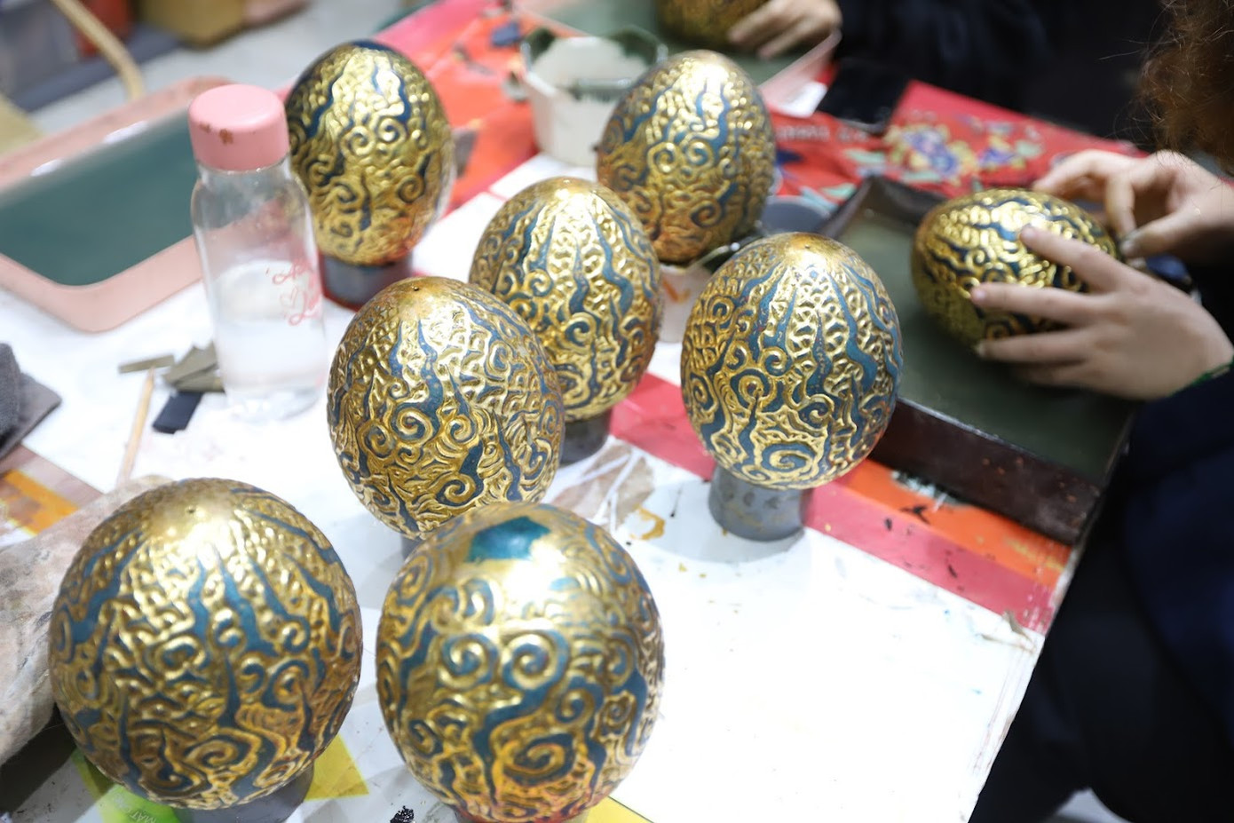 Những quả trứng rồng được làm từ gỗ hương cùng chất liệu sơn mài truyền thống. Vỏ trứng là hoa văn mây lửa cách điệu từ đồ án văn hóa trên bậc thềm đá Điện Kính Thiện - Bảo vật Quốc gia tại Hoàng Thành Thăng Long. Những đám mây cuồn cuộn với ý nghĩa mưa thuận gió hòa, mùa màng bội thu. Những quả trứng rồng được làm từ gỗ hương cùng chất liệu sơn mài truyền thống. Vỏ trứng là hoa văn mây lửa cách điệu từ đồ án văn hóa trên bậc thềm đá Điện Kính Thiện - Bảo vật Quốc gia tại Hoàng Thành Thăng Long. Những đám mây cuồn cuộn với ý nghĩa mưa thuận gió hòa, mùa màng bội thu.