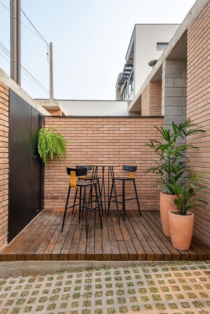 Thay vì bố trí hai chỗ đậu xe, ngôi nhà chỉ dành một vị trí để đỗ ô tô, phần còn lại được tận dụng làm sàn gỗ ngoài trời, tích hợp khu vực nướng BBQ - nơi gắn kết gia đình và bạn bè trong những buổi tụ họp.