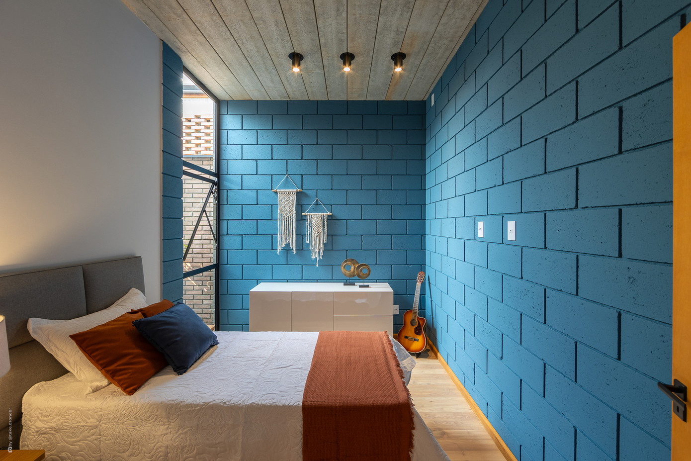 Về phong cách kiến trúc, ngôi nhà mang hơi hướng công nghiệp hiện đại nhưng vẫn giữ được sự ấm áp đặc trưng của một tổ ấm. Các vật liệu được lựa chọn kỹ lưỡng từ gạch bê tông lộ thiên, gạch đất nung đặc cho đến sàn gạch mosaic xanh trắng trong khu bếp. Màu sắc cũng được sử dụng một cách tinh tế với tông xanh lam mát mắt cho phòng ngủ đầu tiên và màu đất nung ấm áp cho phòng ngủ chính.