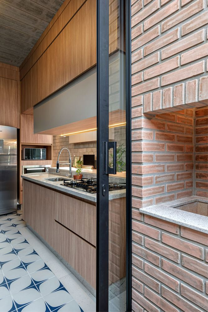 Điểm đặc biệt là bếp và khu nướng BBQ chỉ ngăn cách bởi cửa trượt âm tường, vừa tiết kiệm diện tích, vừa loại bỏ nhu cầu lắp đặt thêm bồn rửa hoặc tủ đông riêng biệt.