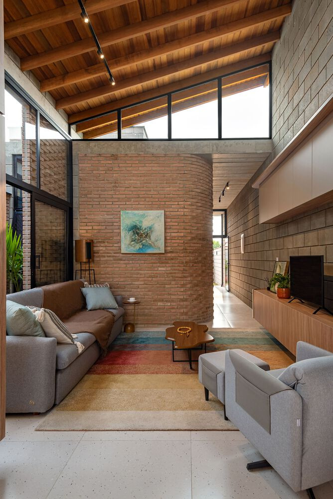 Một điểm nhấn khác là khoảng thông tầng phía trước khu vườn mùa đông, nơi phần mái được cắt rỗng 3,6x3,6m, nâng chiều cao trần và tạo không gian tràn ngập ánh sáng tự nhiên. Hai cửa sổ hình tam giác được bố trí tại đây không chỉ tăng tính thẩm mỹ mà còn giúp đối lưu không khí trong nhà.