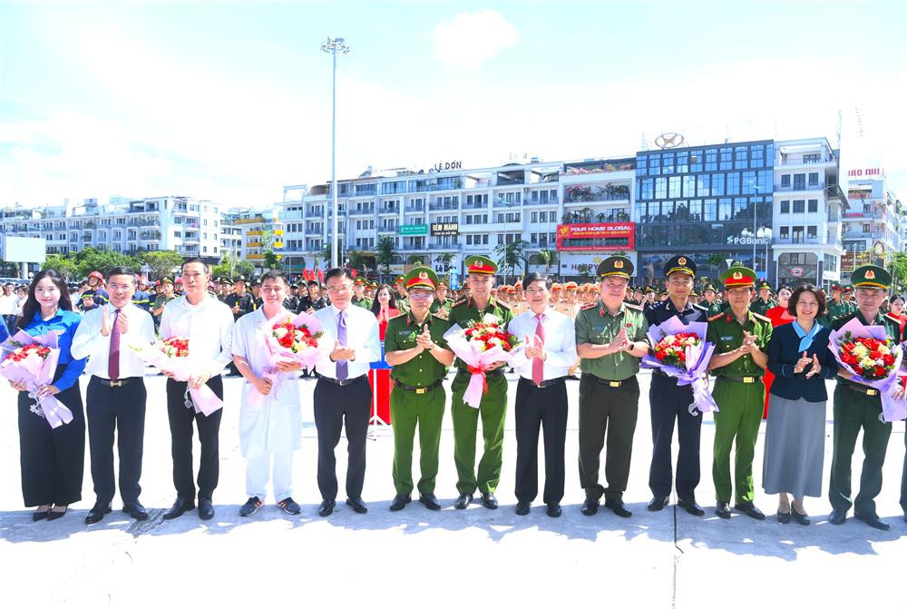 Phó Thủ tướng Chính phủ Lê Thành Long cùng các đại biểu tặng hoa động viên các lực lượng tuần hành hưởng ứng Tháng hành động PCMT, Ngày Quốc tế PCMT và Ngày toàn dân PCMT.